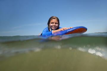 young girl surfing in summer at the beach