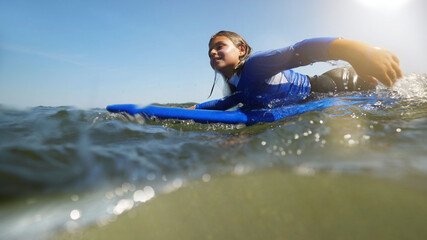 Naklejka premium young girl surfing in summer at the beach