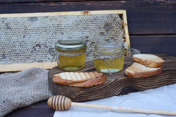 Fresh fragrant honey in a glass jar on a wooden background on the table. Different types of bee honey. Natural products.