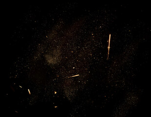 Dust and wood chips on a black background. Dirt particles fly in the air. Layout for design. Some...