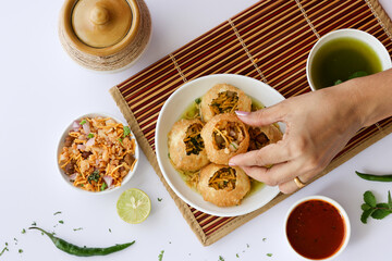 Girl women taking spicy Pani puri golgappe with hand, Chat item, India. North Indian street food  Indian panipuri snack eaten tangy tamarind water, potato stuffing Delhi, Mumbai, Holi Diwali Dussehra