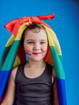 Girl with rainbow flag tied on head on blue background