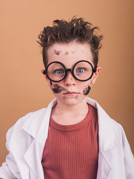 Crazy scientist boy with dirty face in decorative eyeglasses