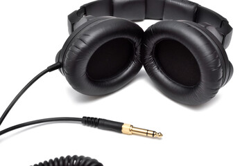 Studio headphones for listening, mixing and recording music. Black wired professional stereo headphones on white background.