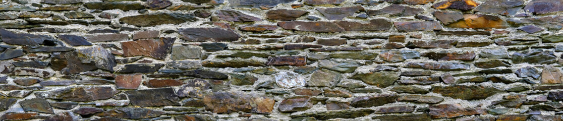 beautiful vintage texture of the wall of a medieval castle built in the middle of the 14th century, multi-colored volumetric stones for the designer, long banner, wallpaper, background