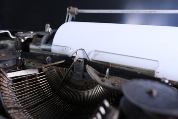 old typewriter on table, blank white sheet for text, mockup, retro style, concept of works of a writer, journalist