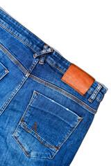 Jeans with blank leather label and back pockets on white background.