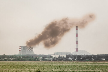 Fototapeta na wymiar Pollution of the environment and ecology. Dirty production, smoke from the cooling tower of an industrial enterprise near the chimney