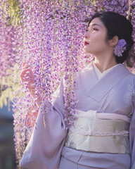 着物を着た女性と藤の花