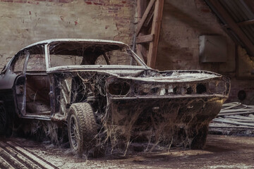 Old disassembled car in an abandoned factory