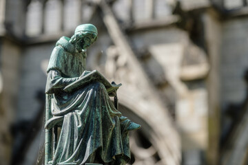 Fototapeta premium Statue writing monk in the Dom Garden of Utrecht, Utrecht Province, The Netherlands