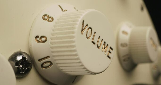 Hand Turning Up Electric Guitar Volume Knob Extreme Close Up