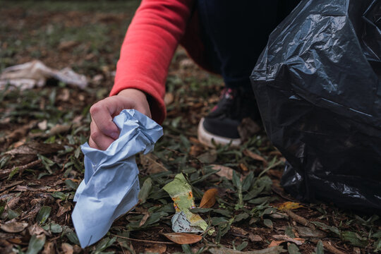 Anonymous e child collecting garbage from land in forest