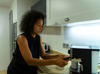 Colombian woman prepares coffee in her kitchen