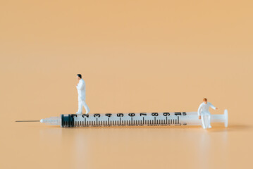 Miniature people Doctor and Nurse emergency medical team walking on syringe with copy space using for digital health retreat take care for covid-19 Coronavirus Immunization vaccinated Hospitality Ads