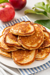 Homemade apple pancakes in a white plate on a gray concrete background. Tasty breakfast