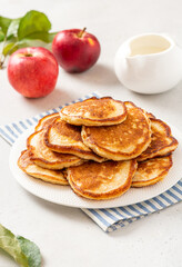 Homemade apple pancakes in a white plate on a gray concrete background. Tasty breakfast