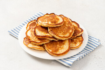 Homemade pancakes in a white plate on a gray concrete background. Tasty breakfast