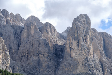Fototapeta premium Alta Badia (Dolomiti) - August: Beautiful summer mountain view of Passo Sella and high peak Sassopiatto and Sassolungo, Langkofel, Dolomiti, Sella group. Green meadows and pastures, alpine dolomites