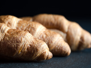 Fresh croissants on black slate background
