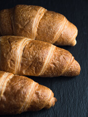 Fresh croissants on black slate background