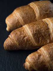 Fresh croissants on black slate background