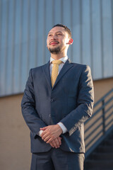 	
Young executive in blue suit standing at the entrance of his company	
