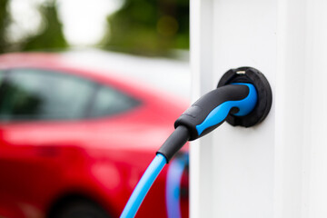 Electric car charging at plug in charge station in a public car park in Suffolk, UK