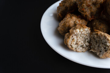 Chicken kofta meatballs mixed with ingredients of onions, garlic fresh herbs and spices mixture on black background