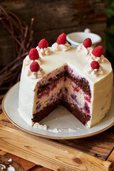 Chocolate raspberry cake with raspberry cheesecake layer. Decorated with berries. Side view