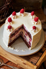 Chocolate raspberry cake with raspberry cheesecake layer. Decorated with berries. Side view