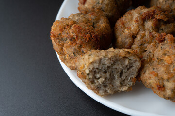 Chicken kofta meatballs mixed with ingredients of onions, garlic fresh herbs and spices mixture on black background