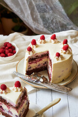 Chocolate raspberry cake with raspberry cheesecake layer. Decorated with berries. Side view