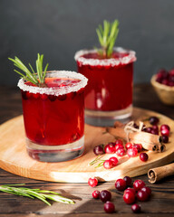 Winter drink on a wooden background. Cranberry tea with rosemary. A warming berry drink. Hot tea with berries and cinnamon.