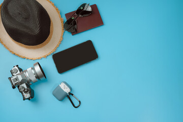 flat lay travel accessory in new normal with phone camera and passport on blue background
