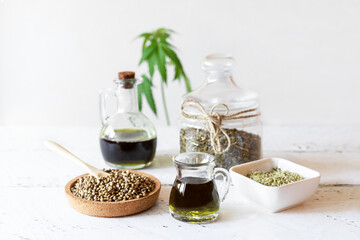 Obraz na płótnie Canvas Hemp products: oil, tea, seeds shelled and whole, yogurt with seeds, cannabis plant