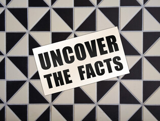 Uncover the Facts card on wooden background. Social concept. Business concept