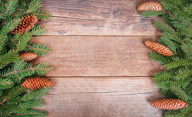 Christmas tree branches with cones are lying on wooden boards