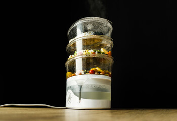 Cooking in the steamer. Healthy, diet food preparing in a steam cooker. - obrazy, fototapety, plakaty