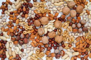 Various types of nuts. Walnuts, Hazelnuts, Cashew, Pistachios, Peanuts and Almonds. Different kinds, flat lay composition on a white background.
