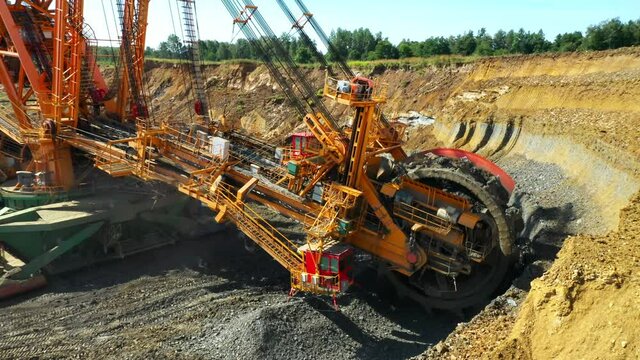Bucket wheel excavator at work in coal mine. Mining industry from above. Open pit in Central Europe. Heavy industry before Green deal.