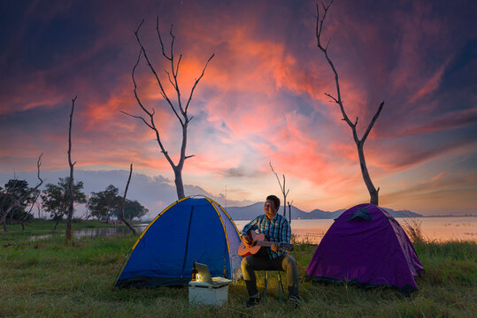 Two young Asian men camping at sunset