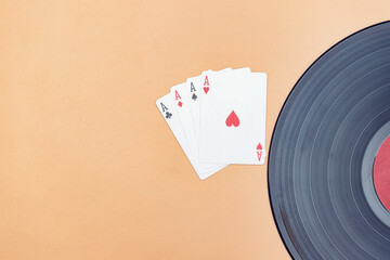 An old vinyl record and a lucky 4 aces in cards