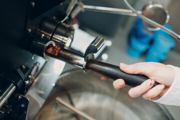 Fototapeta na wymiar Coffee roaster machine tryer at coffee roasting process.