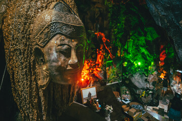 Big Buddha head sculpture in a dark cave in Khao Yai Buddhist temple