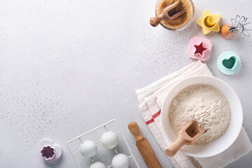 Ingredients for cooking homemade baking. Baking background with flour, eggs, kitchen tools, utensils and cookie molds on white marble table. Top view. Flat lay style. Mock up.
