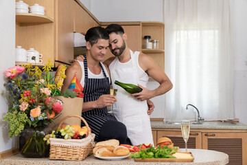 Joyful gay couple celebrating pride month with champagne in kitchen