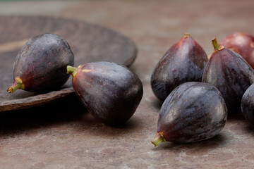 Ripe delicious figs with a bowl on an old wooden background. Food Photo. Whole fresh figs on rustic background.  Selective focus