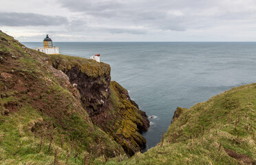 The Lighthouse and foghorn of St Abbs Head Lighthouse, perched on the cliff edge above the North Sea in Berwickshire, Scotland - obrazy, fototapety, plakaty