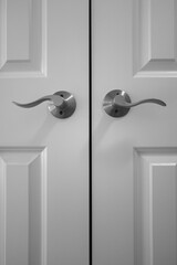 Nickel Accent Privacy Door Lever set installed on white panel interior door. Indoor furniture installation image with the curved doorknob.